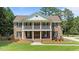Two story brick home with manicured lawn, a symmetrical facade, and a welcoming front porch with seating at 55 Fleming Forest Dr, Youngsville, NC 27596