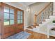 Inviting foyer featuring double doors, hardwood floors, and an elegant staircase with decorative iron railings at 55 Fleming Forest Dr, Youngsville, NC 27596
