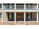 Inviting front porch with white columns, double doors, and seating, offering a charming entrance at 55 Fleming Forest Dr, Youngsville, NC 27596