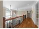 Hallway with hardwood floors, wood and iron railing, arched windows, and recessed lighting at 55 Fleming Forest Dr, Youngsville, NC 27596