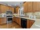 Stylish kitchen with wood cabinets, stainless steel appliances, tile backsplash, and plenty of countertop space at 55 Fleming Forest Dr, Youngsville, NC 27596