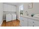 Well-equipped laundry room features modern machines, ample counter space, sink, and bright window at 55 Fleming Forest Dr, Youngsville, NC 27596