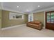 Cozy living room with carpet, light-green painted walls, and a comfortable leather sofa at 55 Fleming Forest Dr, Youngsville, NC 27596