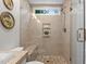 Elegant shower featuring a glass door, pebble-style floor, and a built-in shelf at 55 Fleming Forest Dr, Youngsville, NC 27596