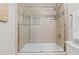 Shower over tub featuring neutral colored tile, glass door, and chrome fixtures at 55 Fleming Forest Dr, Youngsville, NC 27596