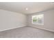 Well-lit bedroom featuring soft carpeting, a bright window with pleasant outdoor views, and neutral wall paint at 55 Shoreline Dr, Lillington, NC 27546