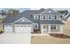 Beautiful two-story blue home featuring a three car garage and landscaped front yard at 55 Shoreline Dr, Lillington, NC 27546