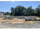 New home foundation of concrete blocks sits on a gravel lot with a tree line in the background at 55 Shoreline Dr, Lillington, NC 27546