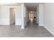 Long hallway featuring grey vinyl floors, trimmed doorways and walls, and a view of the living area at 55 Shoreline Dr, Lillington, NC 27546