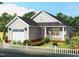 Charming single-story home boasts a manicured lawn, a white picket fence, and an attached garage at 701 East St, Smithfield, NC 27577