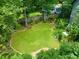 Aerial view of manicured backyard with manicured lawn, garden beds, mature trees, and privacy fencing at 701 Holloway St, Durham, NC 27701