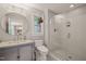 Stylish bathroom boasts subway tile shower, round mirror, and modern fixtures, exuding elegance at 701 Holloway St, Durham, NC 27701