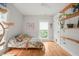 Minimalist bedroom with a cozy bed, natural light, and wooden shelves displaying plants, offering a serene escape at 701 Holloway St, Durham, NC 27701