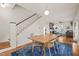 Bright dining area with hardwood floors, white walls, and staircase, complemented by a modern wooden table at 701 Holloway St, Durham, NC 27701