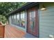 Exterior view showcasing an entrance door with a storm door, surrounded by windows and complemented by a classic light fixture at 701 Holloway St, Durham, NC 27701