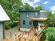 Exterior view of the house showcasing a spacious deck with outdoor dining area, lush greenery, and a well-maintained yard at 701 Holloway St, Durham, NC 27701