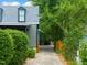 Exterior shot of home shows a quaint driveway leading to the home's entrance, framed by lush greenery at 701 Holloway St, Durham, NC 27701
