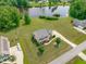 Stunning aerial view of a two-story home with well-manicured lawn near a serene pond at 7217 Leando Dr, Willow Springs, NC 27592