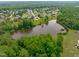Drone shot displaying a pond surrounded by lush greenery and beautiful residential homes at 7217 Leando Dr, Willow Springs, NC 27592