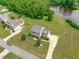 Aerial view of a two-story home with a long driveway, next to solar panels, and a pond at 7217 Leando Dr, Willow Springs, NC 27592