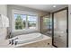 Bathroom showcasing a soaking tub and a separate glass-enclosed shower with lake views at 7217 Leando Dr, Willow Springs, NC 27592