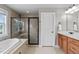 Bathroom featuring a walk-in shower, soaking tub, and vanity with marble countertops at 7217 Leando Dr, Willow Springs, NC 27592