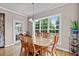 Bright dining area with large windows offering backyard views, hardwood floors and a modern chandelier at 7217 Leando Dr, Willow Springs, NC 27592