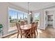 Bright dining room featuring a wood table, hardwood floors, and large windows with a scenic backyard view at 7217 Leando Dr, Willow Springs, NC 27592