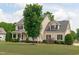 Beautiful two-story home showcasing a lush front lawn, black shutters, and a covered porch at 7217 Leando Dr, Willow Springs, NC 27592