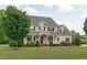 Charming two-story house featuring a well-maintained lawn, covered porch, and mature trees at 7217 Leando Dr, Willow Springs, NC 27592