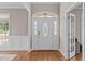 Elegant foyer featuring a decorative front door, hardwood floors, and classic wainscoting at 7217 Leando Dr, Willow Springs, NC 27592