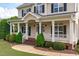 Inviting front porch with white columns and railings, leading to a charming home entrance at 7217 Leando Dr, Willow Springs, NC 27592