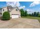 Attached two-car garage with a large driveway and view of backyard pond at 7217 Leando Dr, Willow Springs, NC 27592
