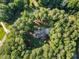Aerial view of a private estate nestled among mature trees with winding driveway and manicured lawns at 7529 Tynewind Dr, Wake Forest, NC 27587