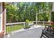 Relaxing back deck with black rocking chairs, a plant stand, and a picturesque view of the wooded backyard at 7529 Tynewind Dr, Wake Forest, NC 27587