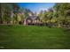 Sprawling backyard featuring lush lawn, mature trees, and a brick house with a deck at 7529 Tynewind Dr, Wake Forest, NC 27587