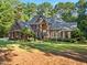 Beautiful brick home with manicured front lawn, surrounded by lush greenery and mature trees at 7529 Tynewind Dr, Wake Forest, NC 27587