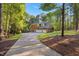 Brick home with a three-car garage and long driveway surrounded by lush greenery at 7529 Tynewind Dr, Wake Forest, NC 27587