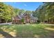 Beautiful brick home with lush front lawn, mature trees, and a welcoming entrance at 7529 Tynewind Dr, Wake Forest, NC 27587