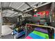 Spacious garage featuring overhead storage, a dark gray car, gym equipment, and toys at 7529 Tynewind Dr, Wake Forest, NC 27587