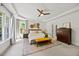 Spacious primary bedroom with tray ceiling, ceiling fan, dresser and large windows at 7529 Tynewind Dr, Wake Forest, NC 27587