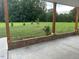 Covered back porch features brickwork and concrete flooring overlooking the spacious backyard at 8 Open View Ln, Timberlake, NC 27583