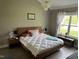Comfortable bedroom with wooden bed frame, white comforter and a ceiling light fixture at 8 Open View Ln, Timberlake, NC 27583