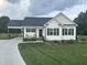 Charming one-story home featuring a landscaped front yard, covered driveway and cozy porch with seating at 8 Open View Ln, Timberlake, NC 27583