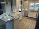 Modern kitchen with white cabinetry, granite countertops, stainless steel appliances, and a breakfast bar at 8 Open View Ln, Timberlake, NC 27583