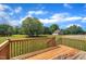 Expansive backyard featuring a wooden deck, lush lawn, mature trees, and a detached garage at 86 Woodall Farm Ln, Princeton, NC 27569