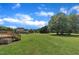 Large backyard with a lawn, trees, deck, and stairs with a view of a two-story home at 86 Woodall Farm Ln, Princeton, NC 27569