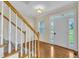 Bright foyer with hardwood floors, a staircase, and a view to the front door and outside at 86 Woodall Farm Ln, Princeton, NC 27569