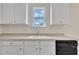 Well-lit kitchen with white cabinets, ample countertop space, and a view of the backyard through the window at 86 Woodall Farm Ln, Princeton, NC 27569