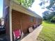 The exterior side of the brick house shows a well-maintained wall, tidy yard, and neatly arranged lawn chairs at 1021 Delray St, Durham, NC 27713